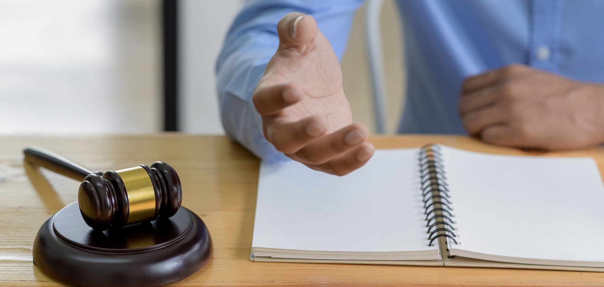 A judge's gavel beside a man with his notebook