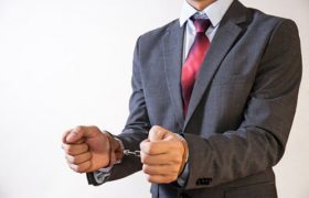 a man in a suit handcuffed