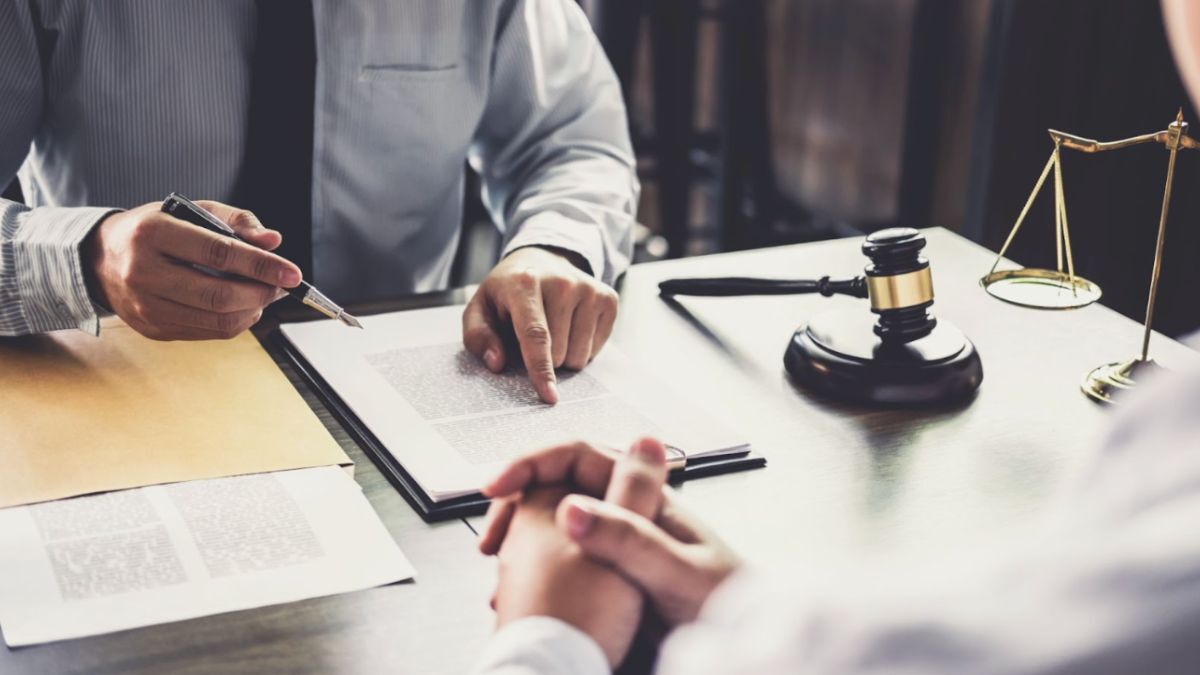 A lawyer and client at a desk, illustrating the value of effective communication and personal compatibility in their interaction.