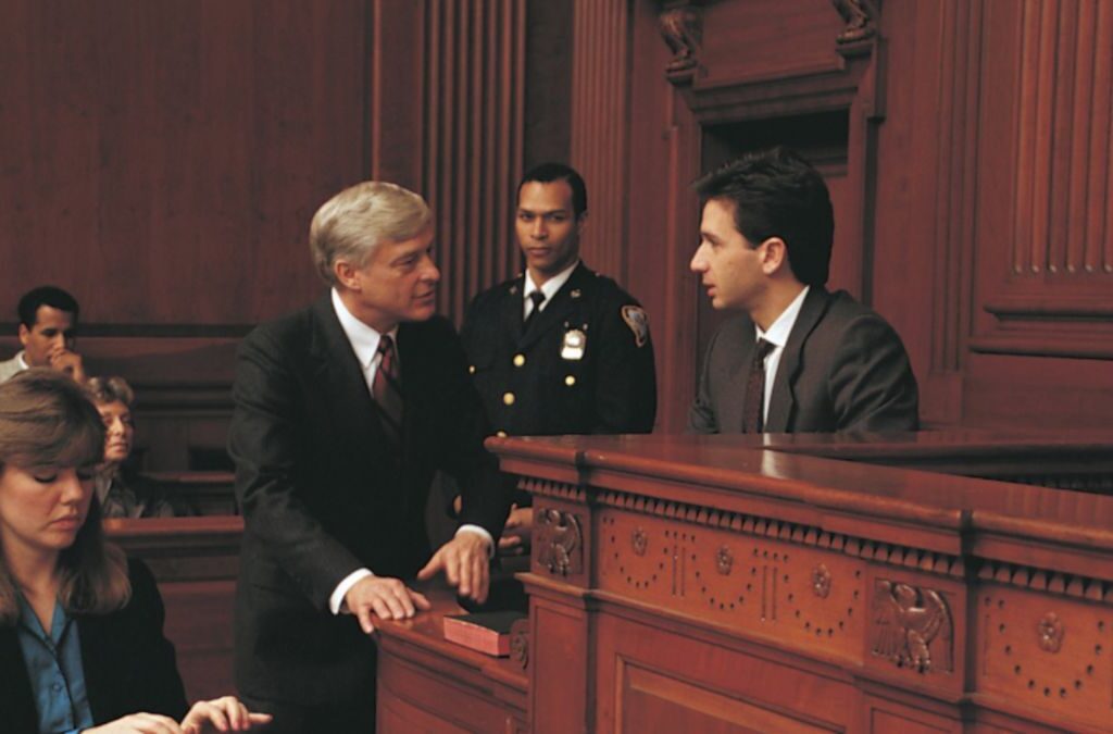 A courtroom scene featuring legal practitioners conversing during legal proceedings.