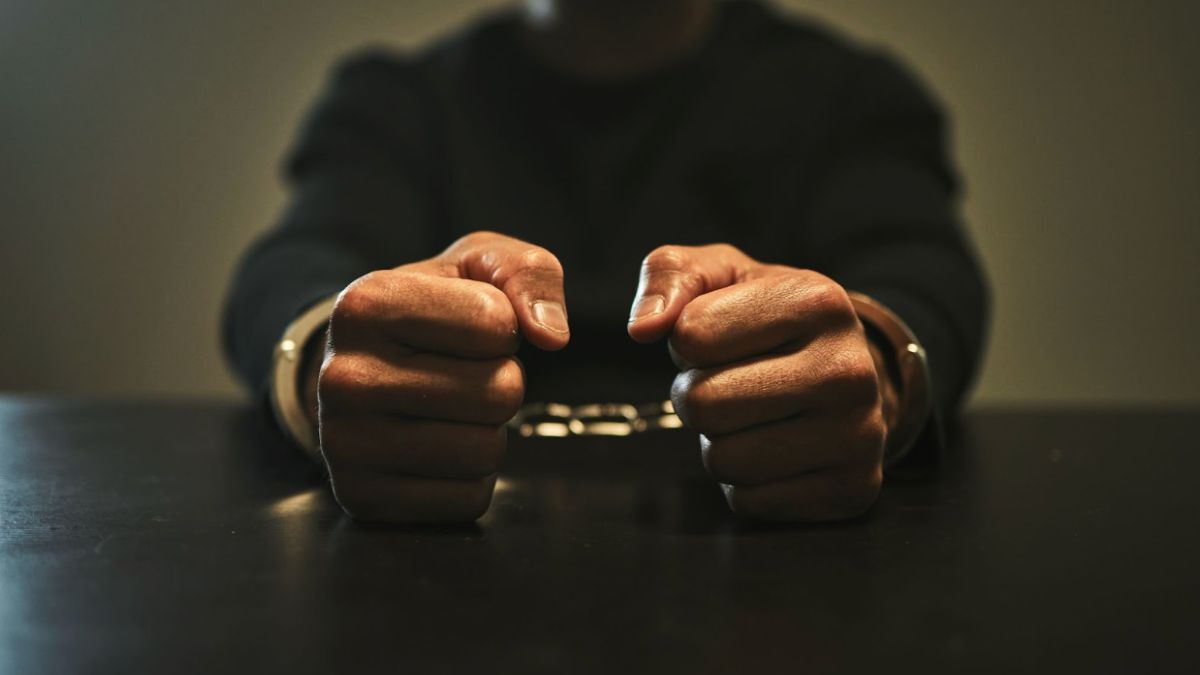 Handcuffed hands of a man on a table, highlighting the legal implications of a kidnapping accusation in Louisiana.