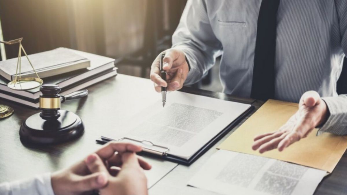 A Baton Rouge legal defense attorney diligently signing papers at a desk, showcasing professionalism and commitment.