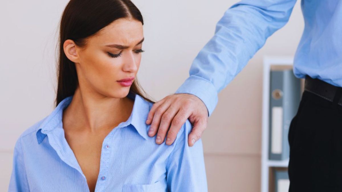 A scene depicting a man in an office environment engaging in an inappropriate act towards a woman, highlighting the issue of sexual assault.