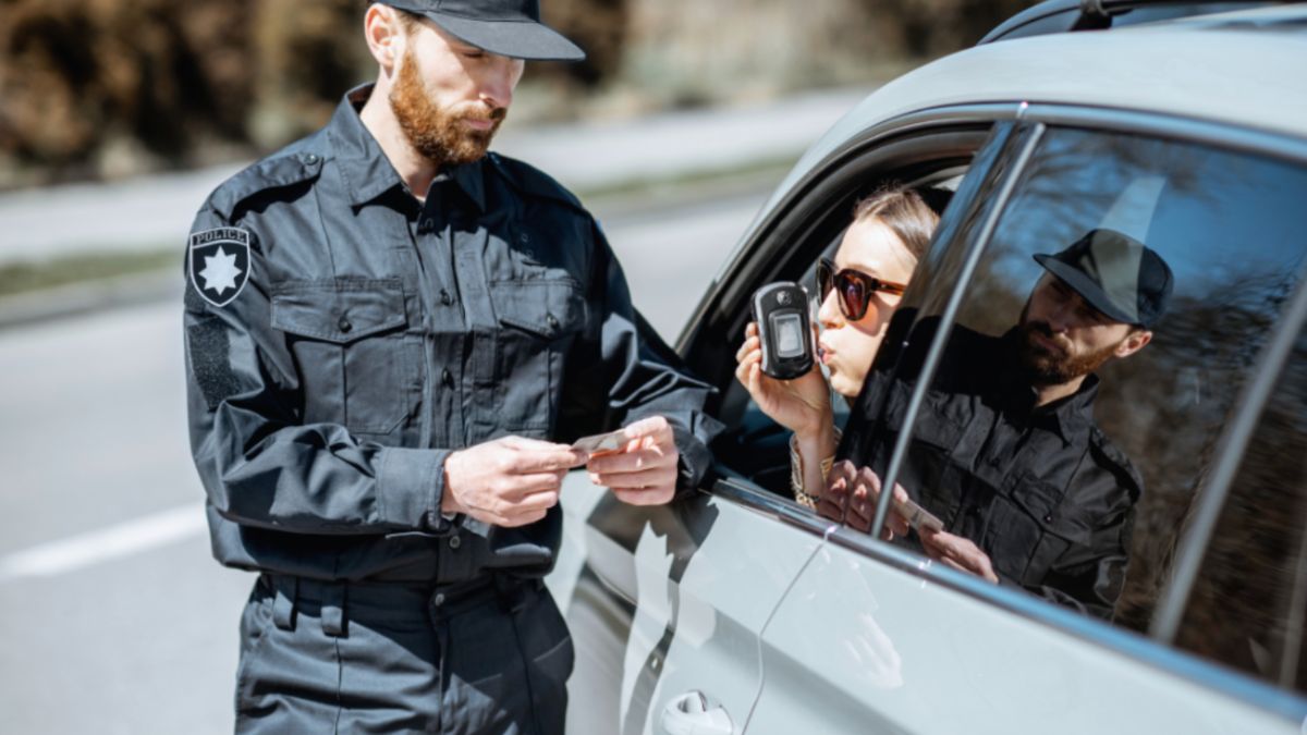 A police officer in uniform examines a woman for a possible DWI violation.