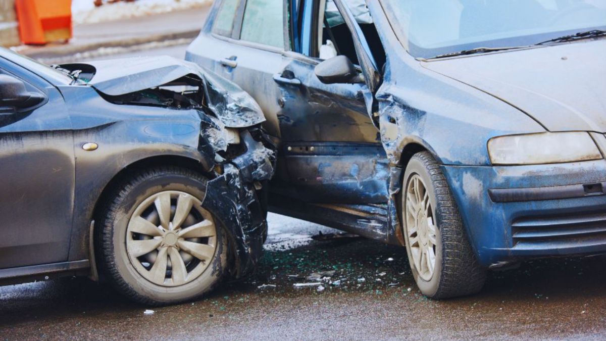 A two-car collision showing severe damage to the front of a black car and the side of a blue car, illustrating the aftermath of a vehicular homicide incident, with debris scattered on the road.