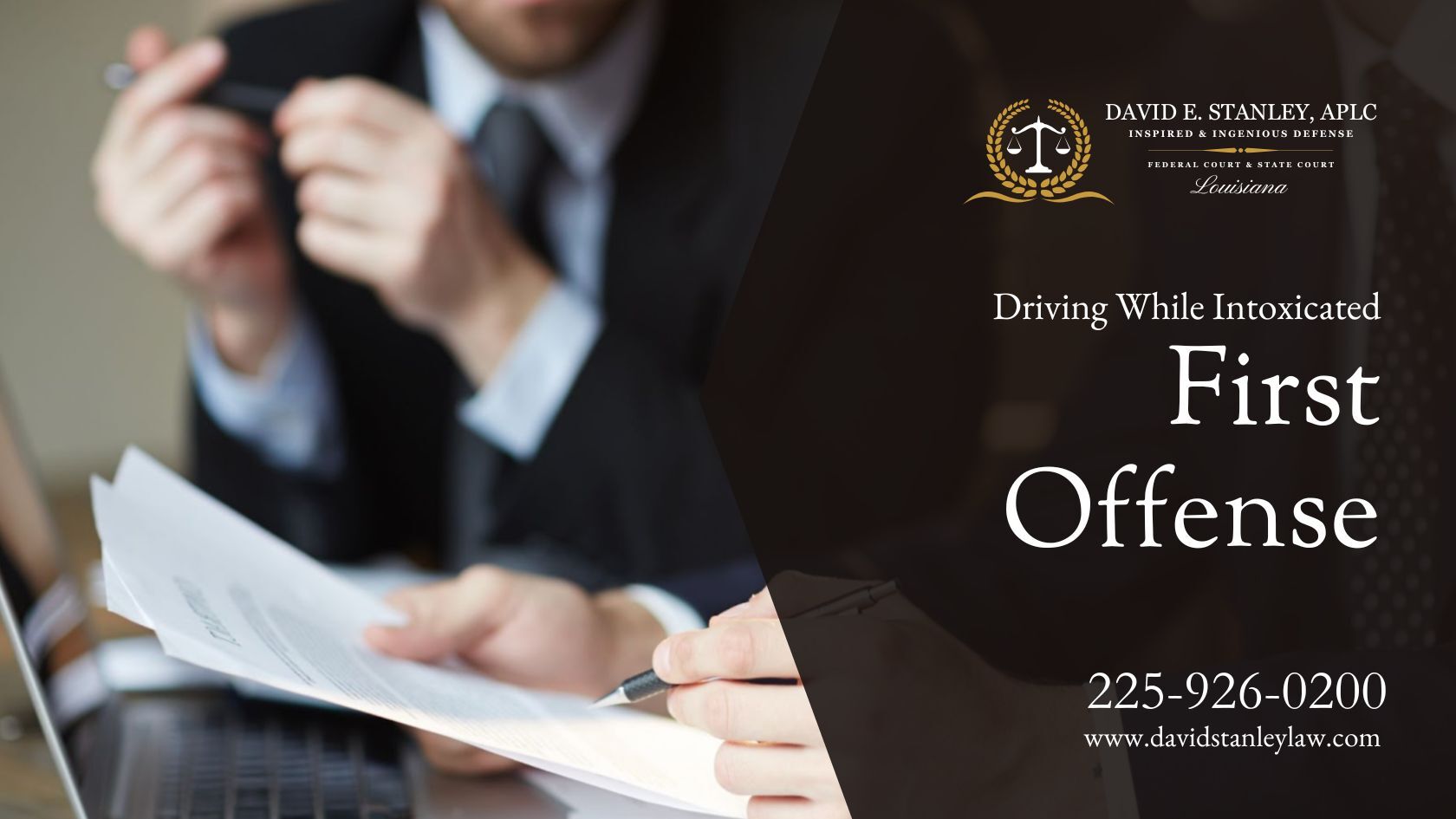 Two attorneys in business suits reviewing DWI-first offense legal documents at a table, representing David E. Stanley, APLC