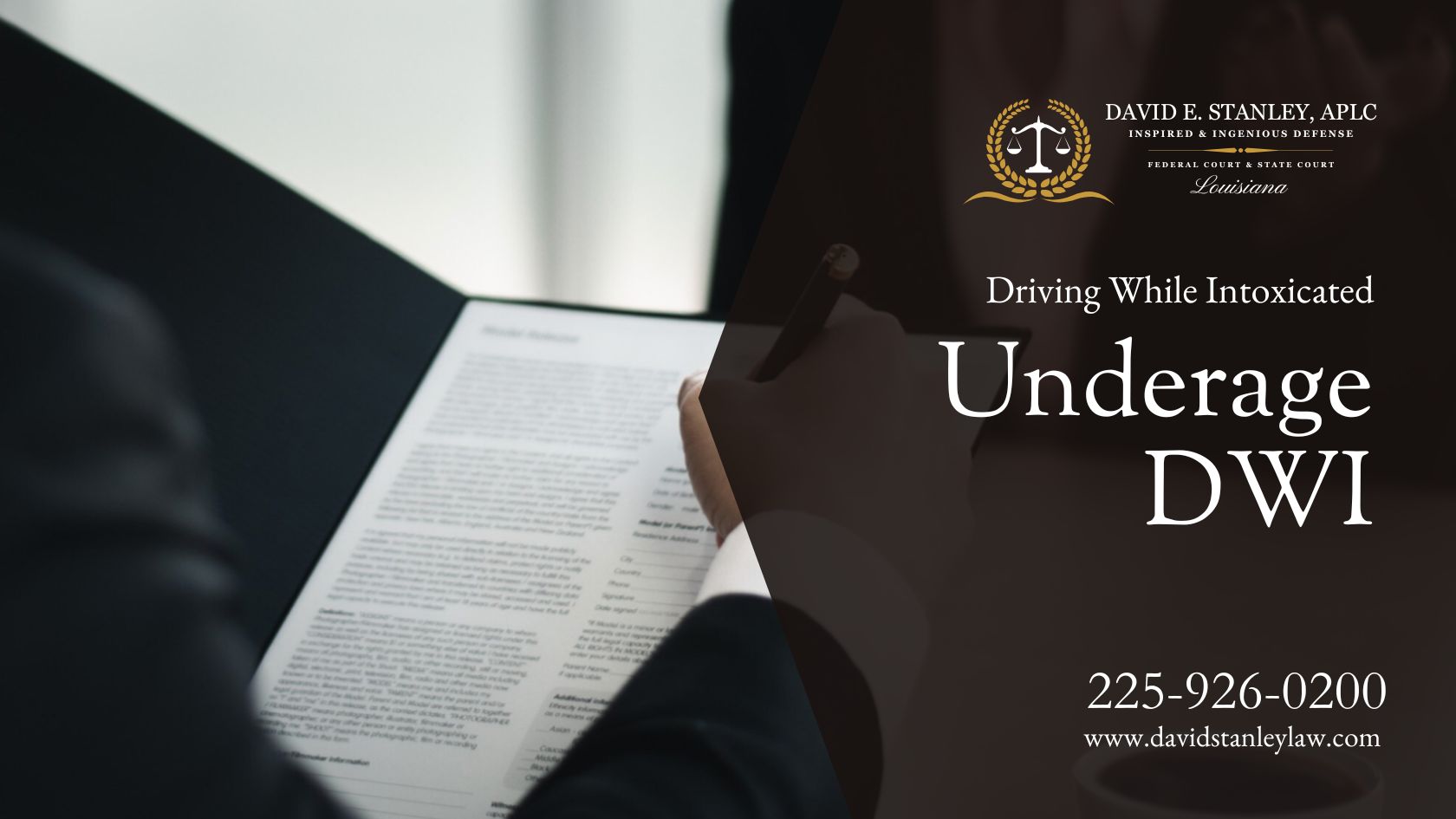 A man in a suit is signing a document related to underage DWI by David E. Stanley, APLC.