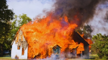 A burning house with flames and smoke rising, illustrating a scene of aggravated arson.
