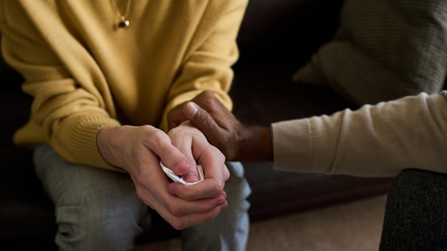 Family member holding hands in support during a confidential legal consultation