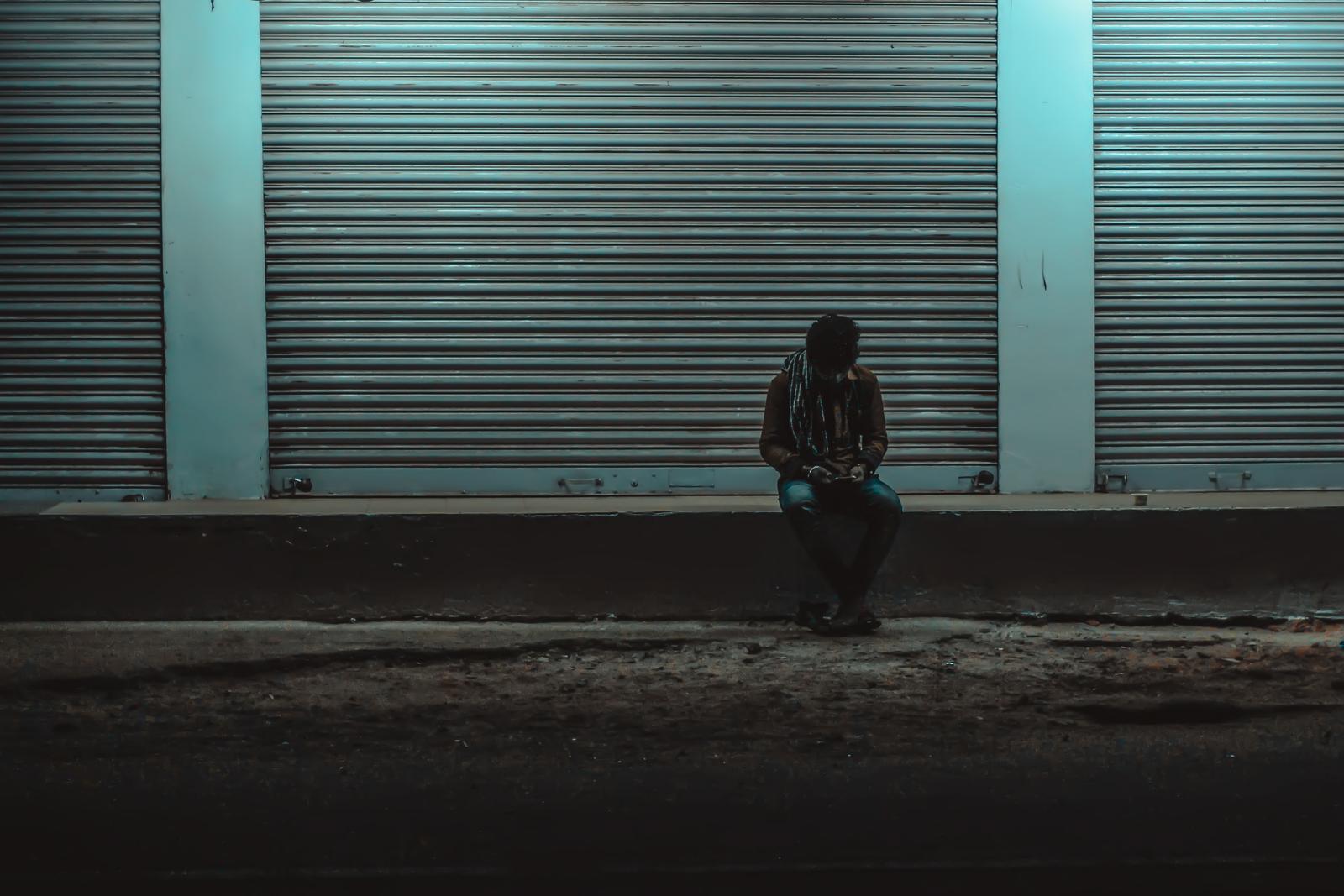 Person sitting alone at night while facing criminal charges