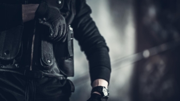 Armed investigator in a tactical vest during a federal criminal investigation