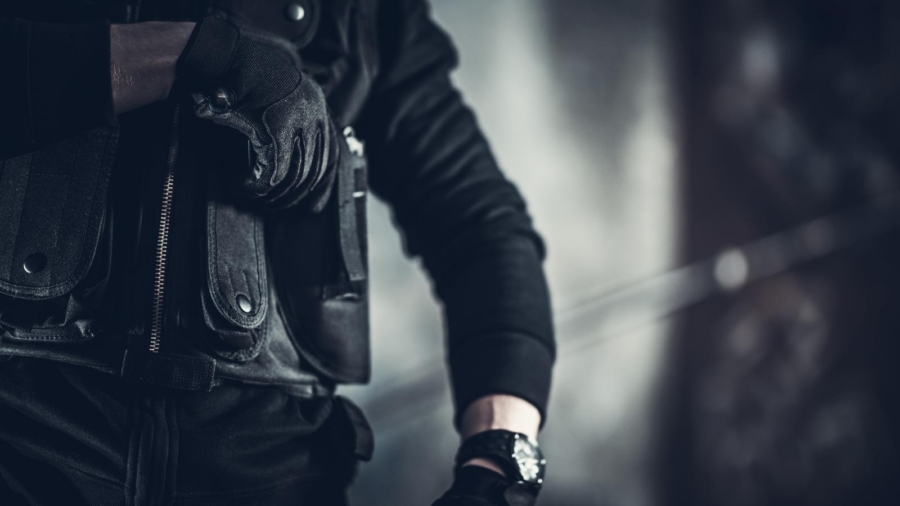Armed investigator in a tactical vest during a federal criminal investigation
