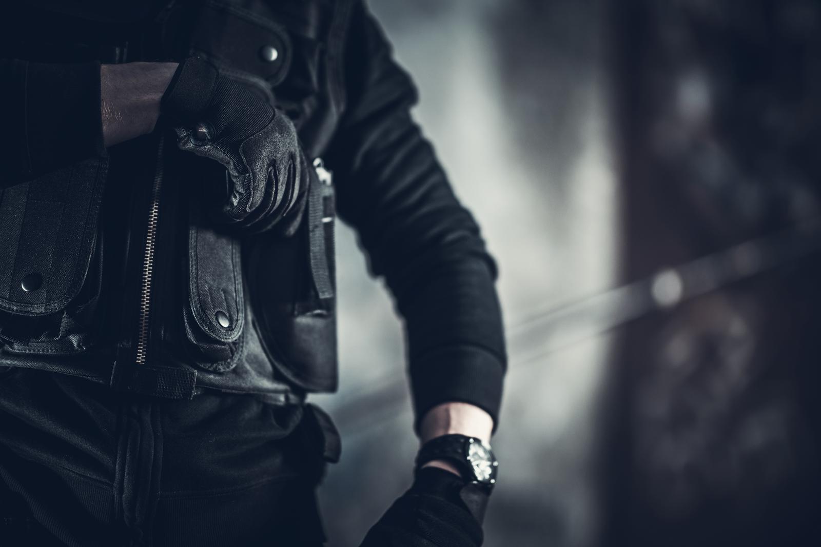 Armed investigator in a tactical vest during a federal criminal investigation