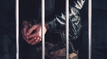Handcuffed man behind bars awaiting a bail hearing in Louisiana