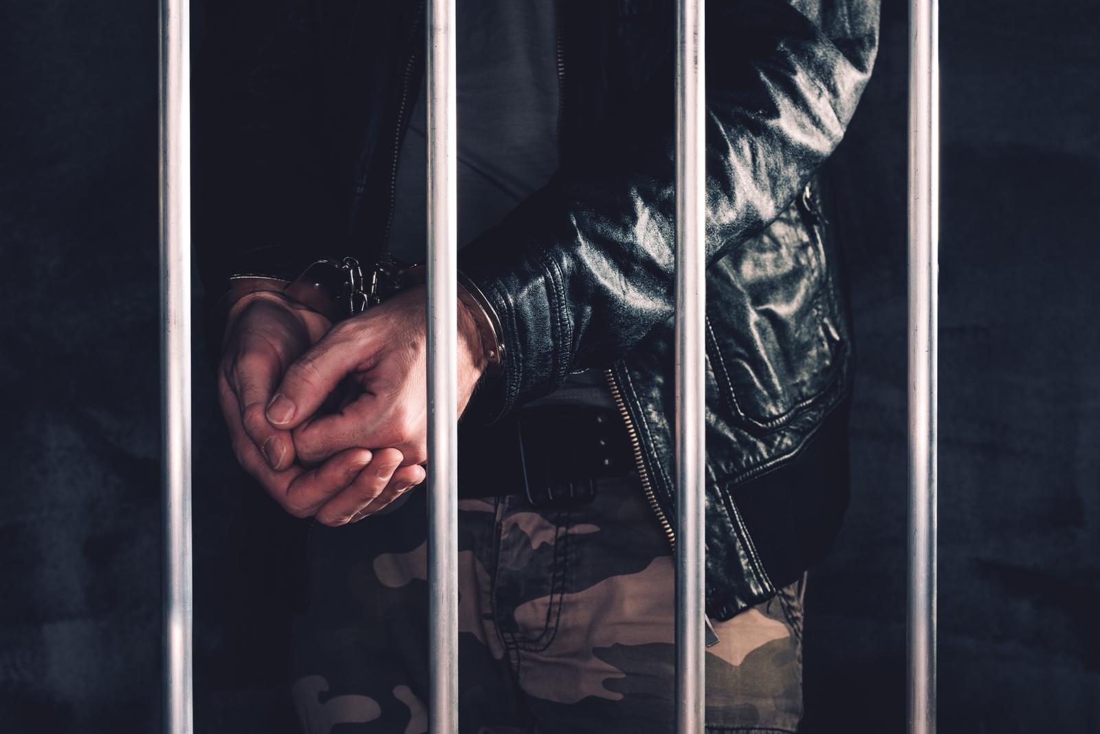 Handcuffed man behind bars awaiting a bail hearing in Louisiana